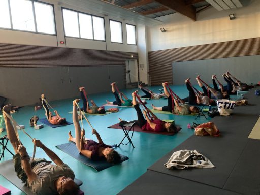 pratique de yoga dans le dojo avec une sangle pour étirer ischio-jambiers